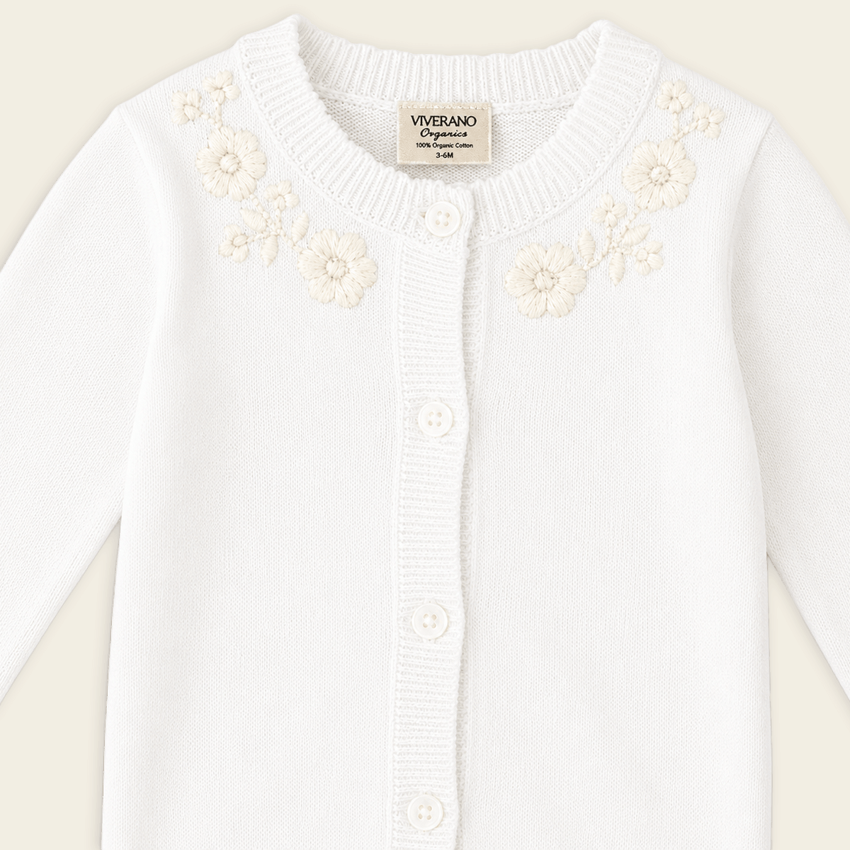 detail of dove white floral embroidered knit baby jumpsuit made with organic cotton