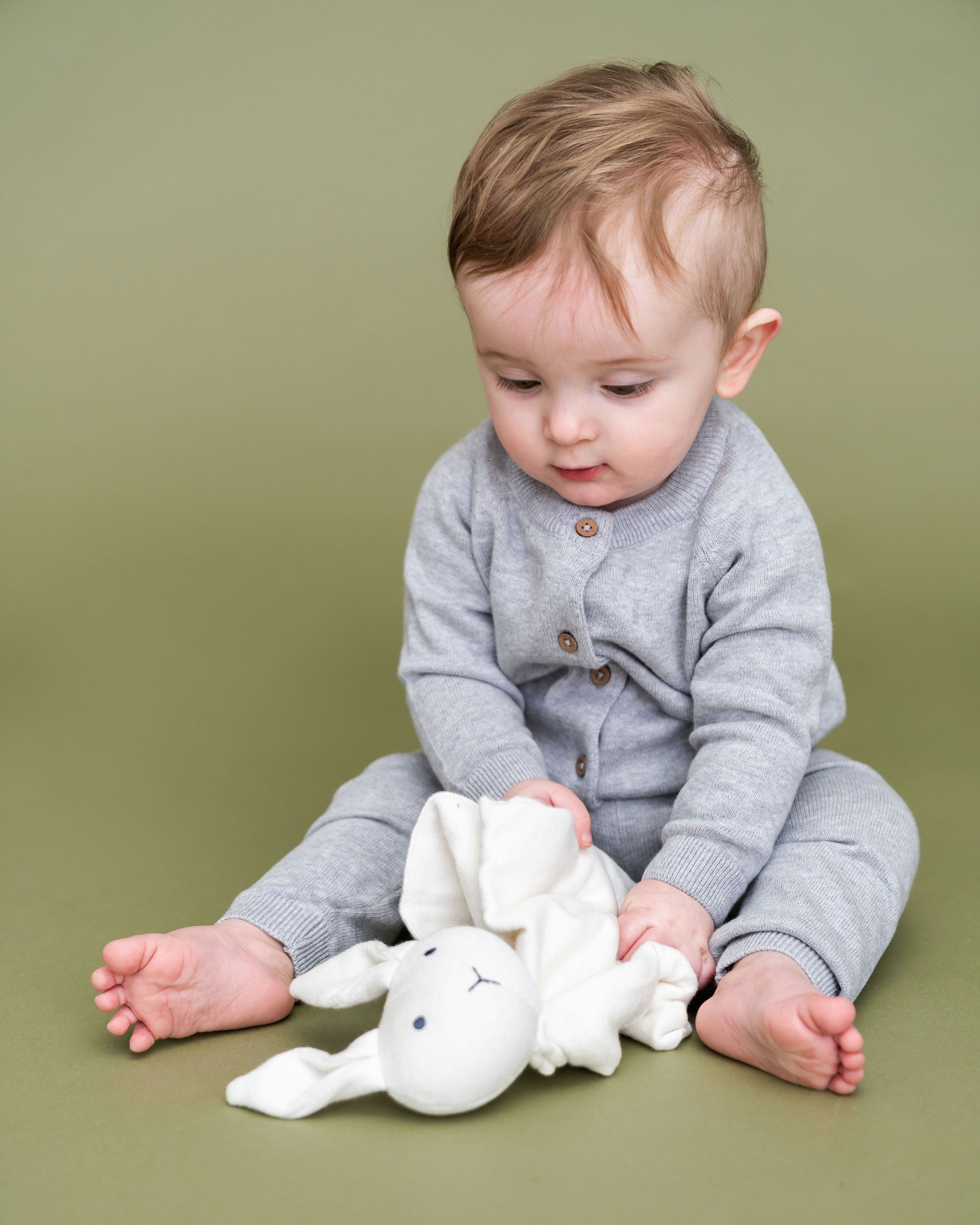 Organic Baby Lovey Security Blanket Cuddle Cloth - Ivory Bunny held by model wearing Viverano Milan outfit