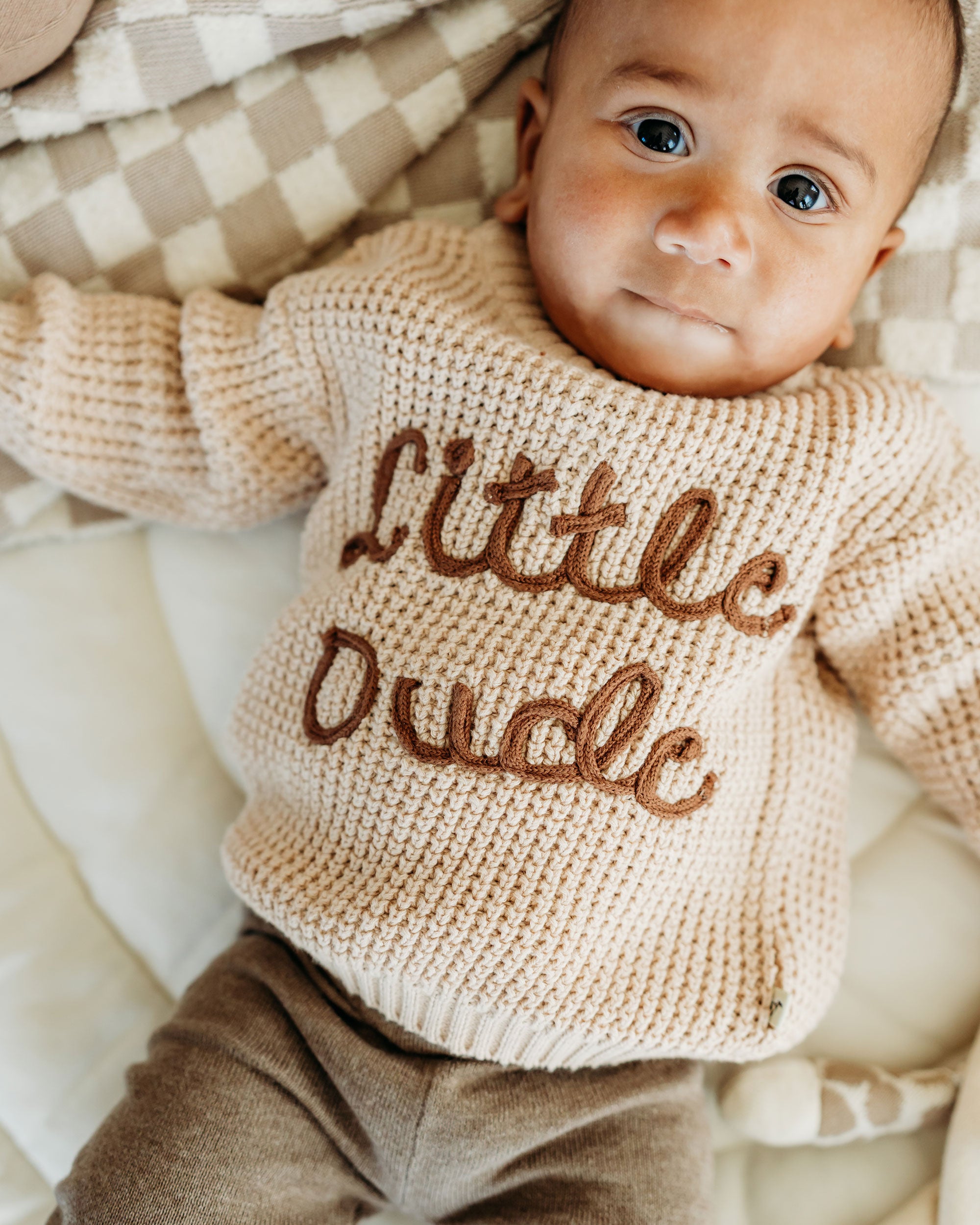 Baby wearing Viverano Organics beige knitted top with Little Dude text in organic cotton